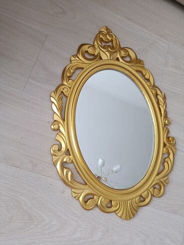 Овальное декоративное зеркало в резной раме золотого цвета в стиле