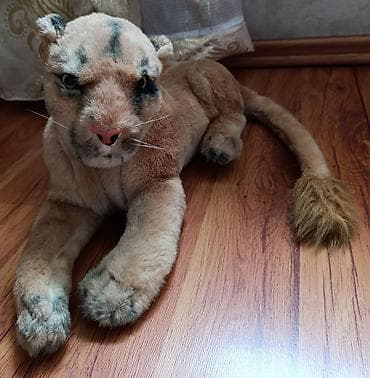 Мягкая игрушка в виде лежащего тигра. Игрушка выполнена из мягкого