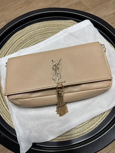 Сумка-клатч бежевого цвета с подвеской-кисточкой и металлическим