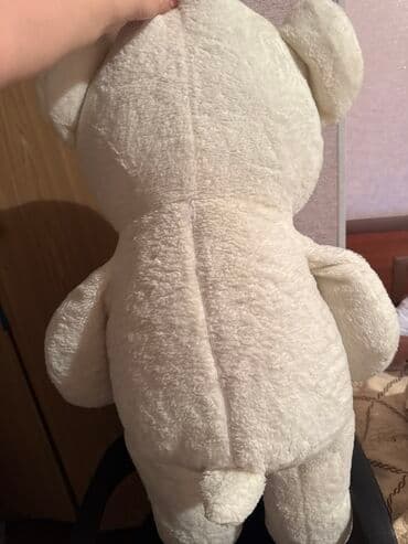 Мягкий белый плюшевый медведь с вышитым сердечком на лапе. У медведя