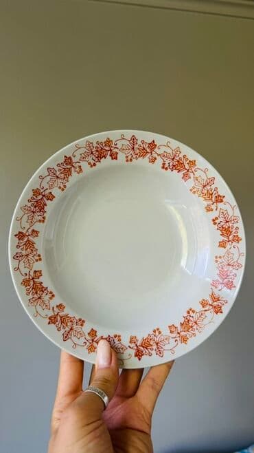 Белая суповая тарелка из фарфора, украшенная узором из листьев и ягод