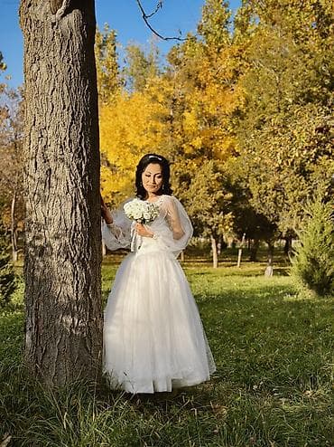 Свадебное платье белого цвета с пышной юбкой и длинным шлейфом