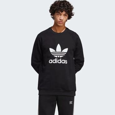 Adidas. Уютный пуловер, отражающий наследие adidas. Логотип