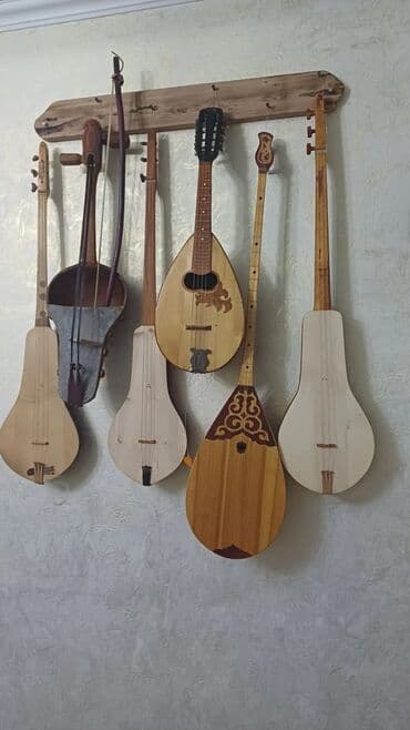 Оруктон жасалган комуздар жана кылкыяктар сатылат, уста озу комузчу