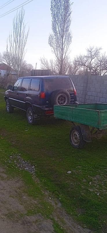 моту ата: Внедорожник 5‑дверный, темно‑синий, с прицепным фаркопом. Кузов — 5