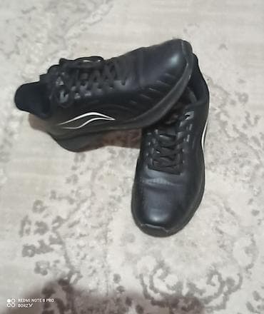 Черные кроссовки/кеды с низким профилем и шнуровкой. Верх выполнен из