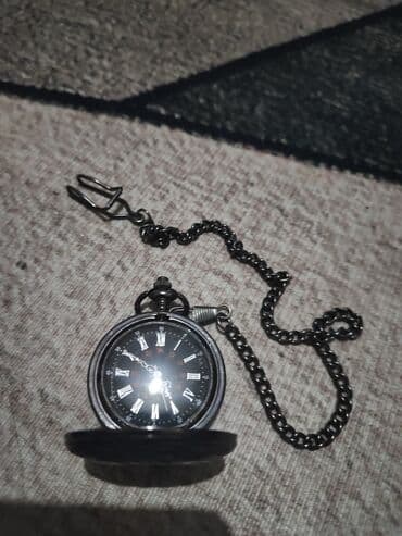 другие аксессуары: Карманные часы в темном корпусе с цепочкой и застежкой. Циферблат — 1