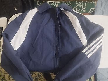 Спортивная ветровка синего цвета с белыми контрастными вставками. -