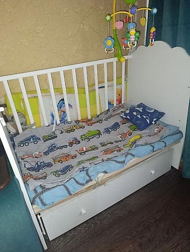 Белая детская кроватка с классическим дизайном, оснащенная боковыми