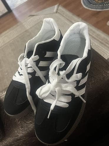 Кроссовки в классическом стиле с тремя белыми полосками по бокам. Верх