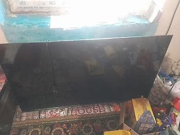 Телевизор с большим экраном (примерно 55–65"). Тонкие рамки, плоская