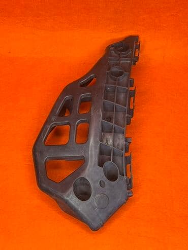 Крепление бампера, выполненное из прочного пластика черного цвета