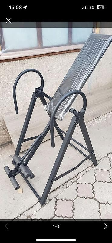 Инверсионный стол черного цвета. Конструкция включает в себя мягкую