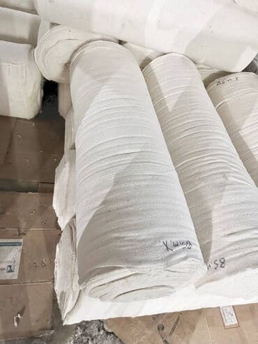 бумага для букетов: Рулоны белой ткани, сложенные и готовые к транспортировке. Этот — 2