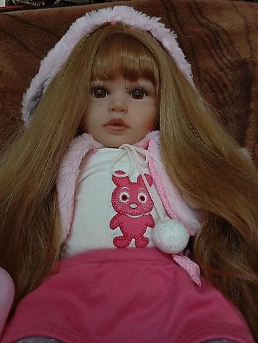 Кукла-реборн, выполненная с вниманием к деталям. У куклы длинные