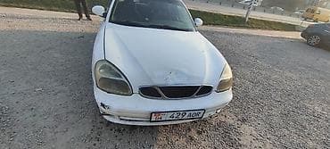 Белый седан компакт‑класса с передним приводом. Кузов 4‑дверный, на