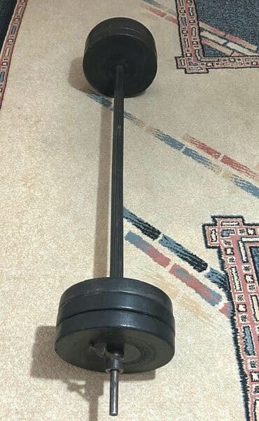 Представлена штанга с набором весовых дисков общий вес составляет