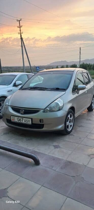 машина экономичный: Хэтчбек Honda Fit в золотистом цвете, оснащенный литыми дисками — 1
