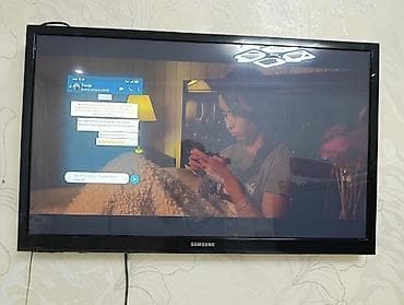 Телевизор Samsung с плоским экраном, диагональ примерно 32–40". -