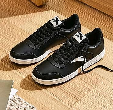 Кроссовки низкие, черные с контрастной белой подошвой. Классический