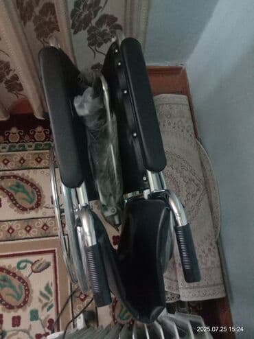 Инвалидная коляска с прочной металлической рамой и черными сиденьем и