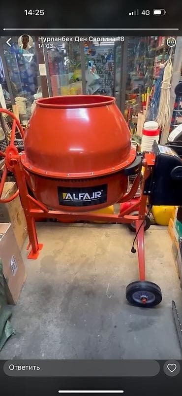 Бетономешалка красного цвета с черным электрическим блоком. Оснащена