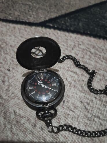 другие аксессуары: Карманные часы в темном корпусе с цепочкой и застежкой. Циферблат — 3