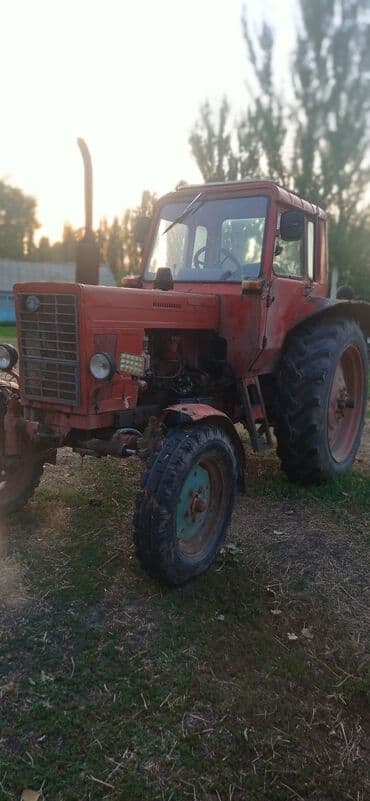 Тракторы ВТЗ: Красный трактор МТЗ, оснащенный кабиной для оператора, предназначен — 5