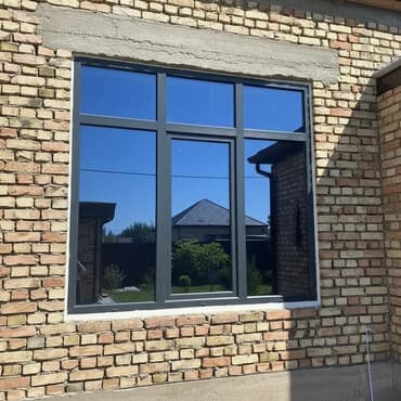 Тонированное окно с черной рамой, состоящее из шести секций: два