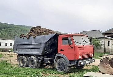 Самосвал КамАЗ красного или оранжевого цвета, предназначенный для