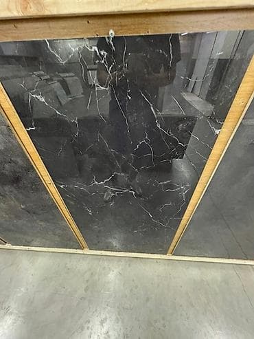 Плитка из керамогранита тёмного цвета с рисунком, имитирующим мрамор с