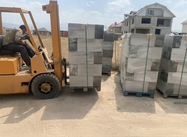 куплю газабетоные оборудование для производства газаблока: Газобетонные блоки светло-серого цвета, аккуратно уложенные на поддоны — 1