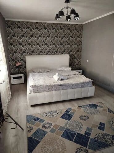 Уютный гостиничный номер с двуспальной кроватью, прикроватными