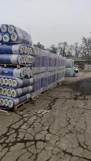 Упаковки рулонной минеральной ваты в синей полиэтиленовой пленке. Этот