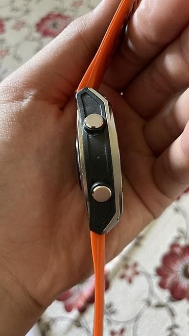 Спортивные смарт‑часы с круглым корпусом и оранжевым силиконовым