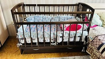 Офис эмереги: Детская кроватка из темного дерева с маятником и выдвижным ящиком. - — 2