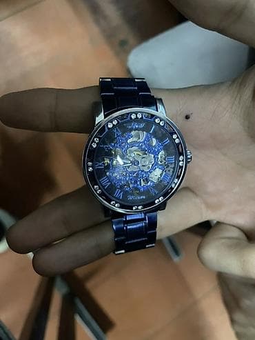 золотые часы: Механические наручные часы с открытым скелетоном и синим оформлением.х — 2