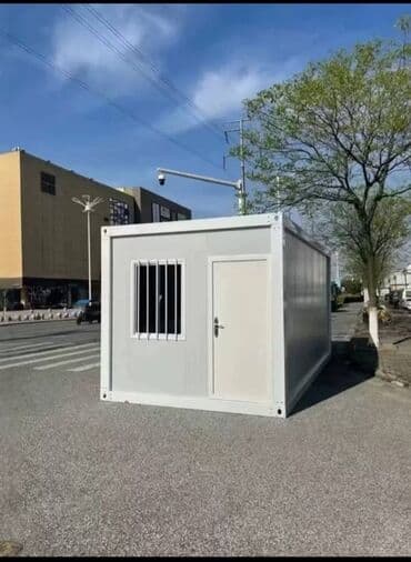 Модульный контейнер серого цвета с белой отделкой. Оснащен дверью и