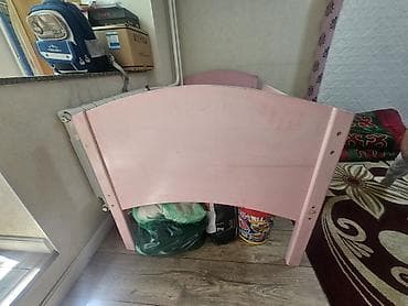 Детская кроватка из дерева, розового цвета.С боку имеется скол -