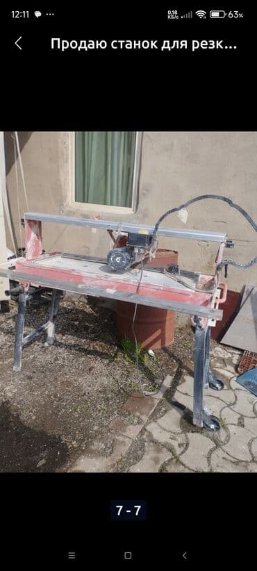 Электрический плиткорез красного цвета на металлической раме