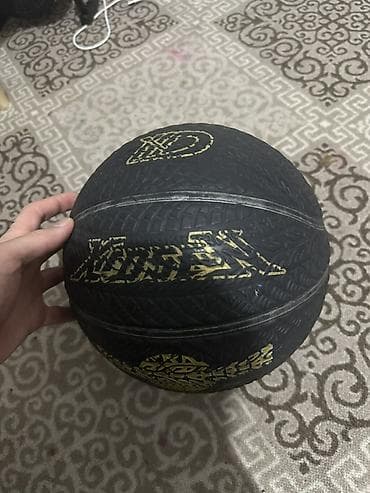 Баскетбольный мяч, черный с золотым орнаментом и логотипами. -