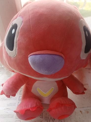 Мягкая игрушка — большой розово‑коралловый персонаж с огромными