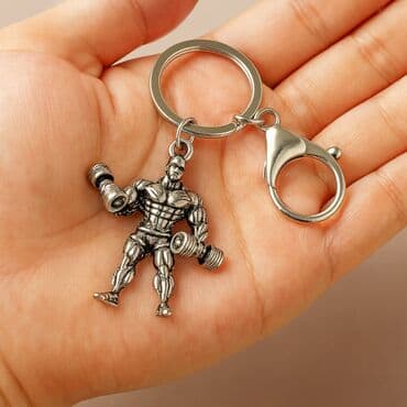 спортивное оборудование: Металлический брелок "Бодибилдер с гантелями" Стильный и мощный — 1