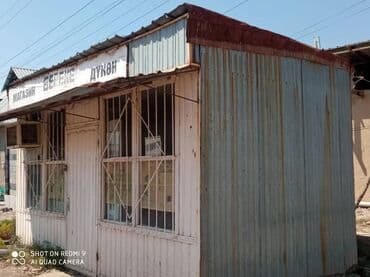 куплю этажный дом: Металлический киоск белого цвета с двускатной крышей. На фасаде — 2