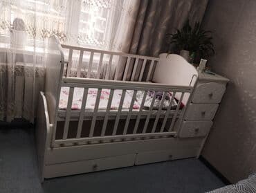 Белая деревянная кроватка, предназначенная для комфортного сна