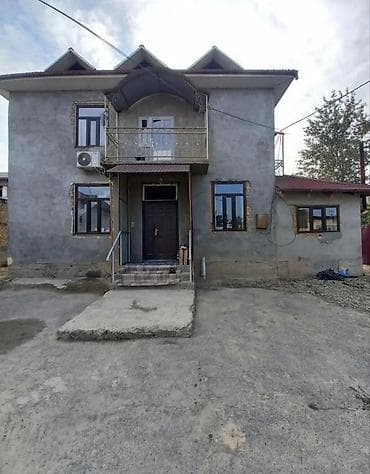 Просторный двухэтажный дом с мансардными окнами и балконом. -