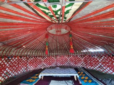 Юрта с красной внутренней отделкой и бамбуковым каркасом. Внутри