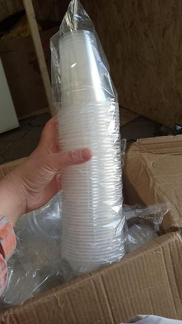 Прозрачные одноразовые пластиковые стаканы в пленочной упаковке. -