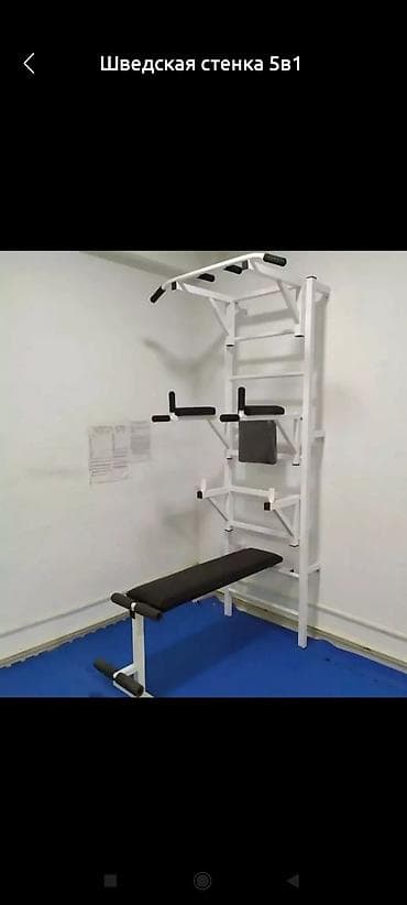 Шведская стенка белого цвета с турником, брусьями и скамьей для