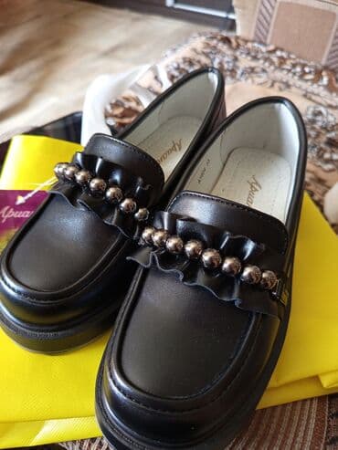 детская ортопедическая обувь: Классические детские лоферы черного цвета от "Ариана" с декоративной — 1